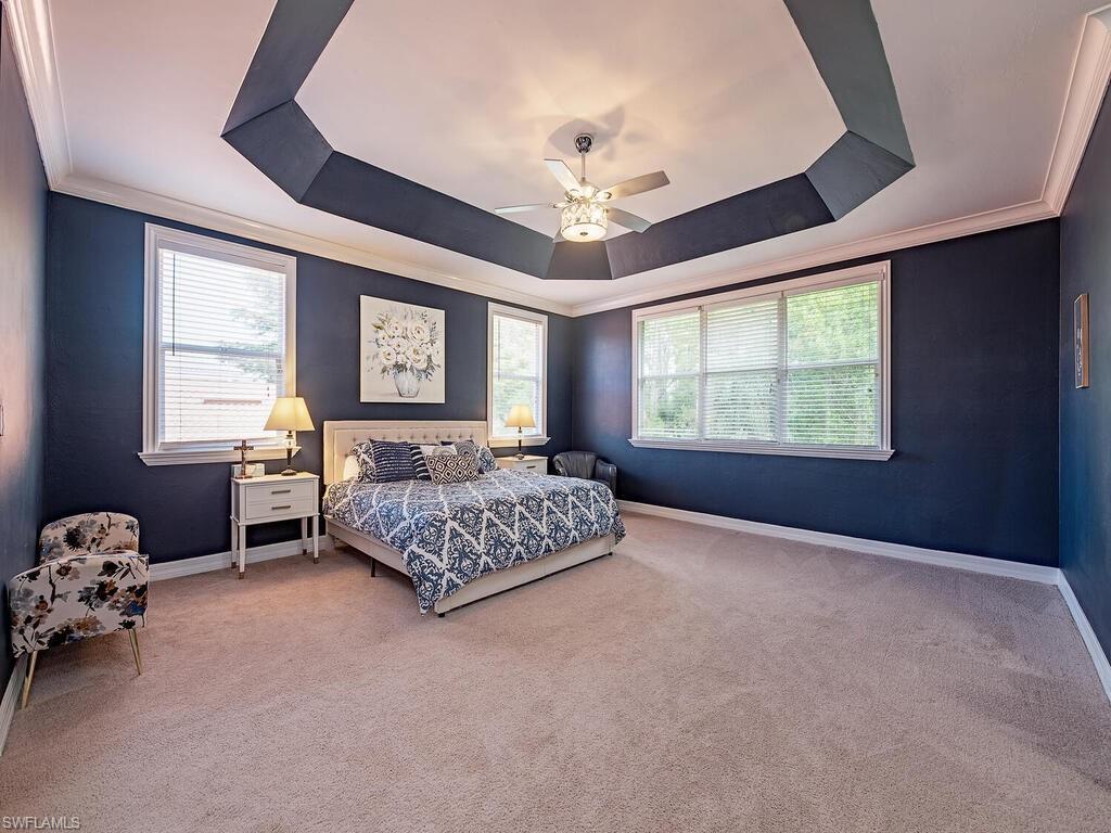 2346 Butterfly Palm Drive Naples, FL 34119 - Photo 14 of 45 Carpeted bedroom with a raised ceiling, ornamental molding, multiple windows, and a ceiling fan