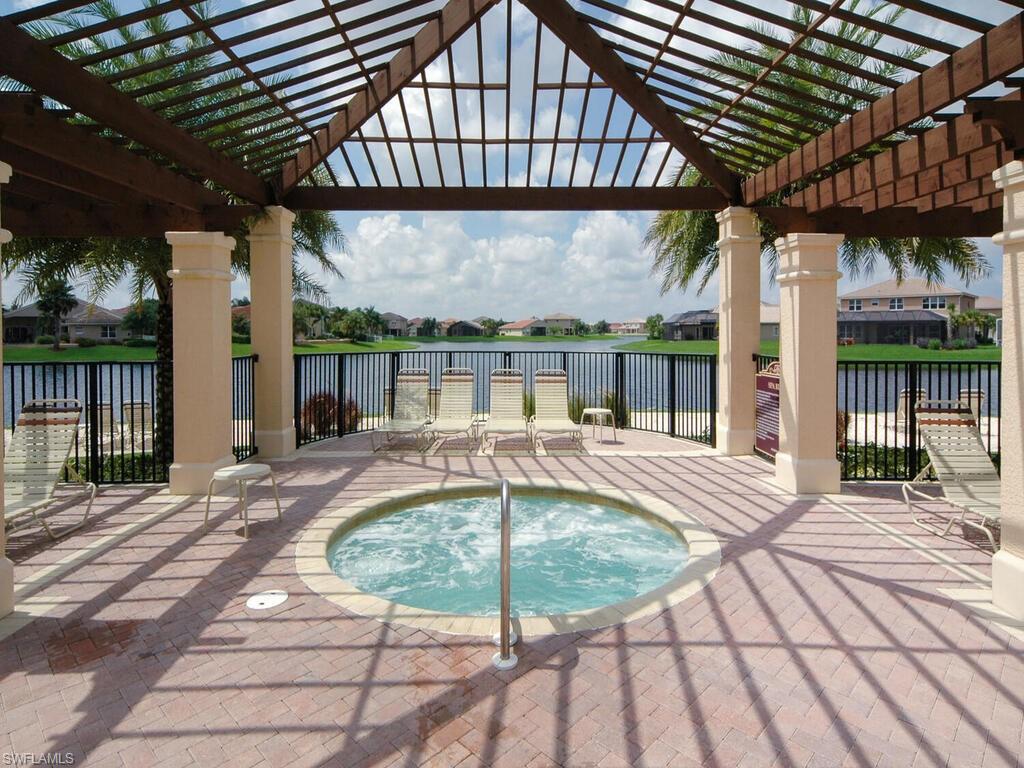 2346 Butterfly Palm Drive Naples, FL 34119 - Photo 19 of 45 View of swimming pool featuring a patio area, a pergola, a hot tub, a residential view, and a water view