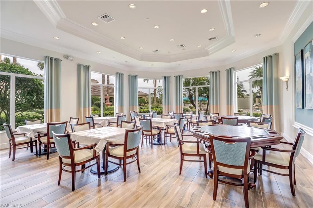 2346 Butterfly Palm Drive Naples, FL 34119 - Photo 24 of 45 Dining room featuring light wood-style floors, a raised ceiling, plenty of natural light, and ornamental molding