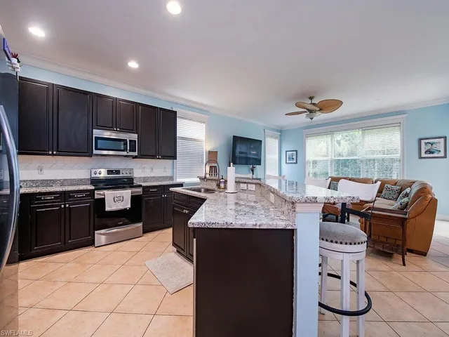 a kitchen with kitchen island granite countertop a stove sink and cabinets