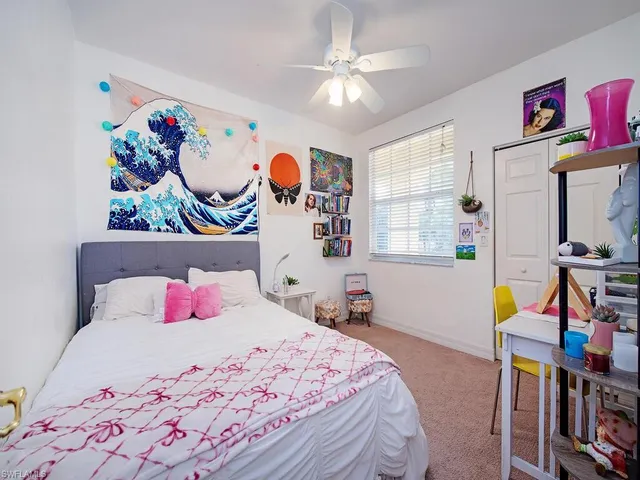 a bedroom with a bed a window and book self