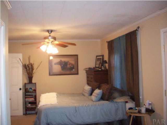 3900 Macks Road Century, FL 32535 - Photo 15 of 24 a bedroom with a bed and a chandelier