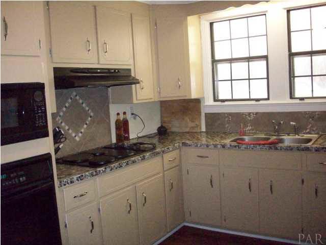 3900 Macks Road Century, FL 32535 - Photo 5 of 24 a kitchen with granite countertop white cabinets and sink