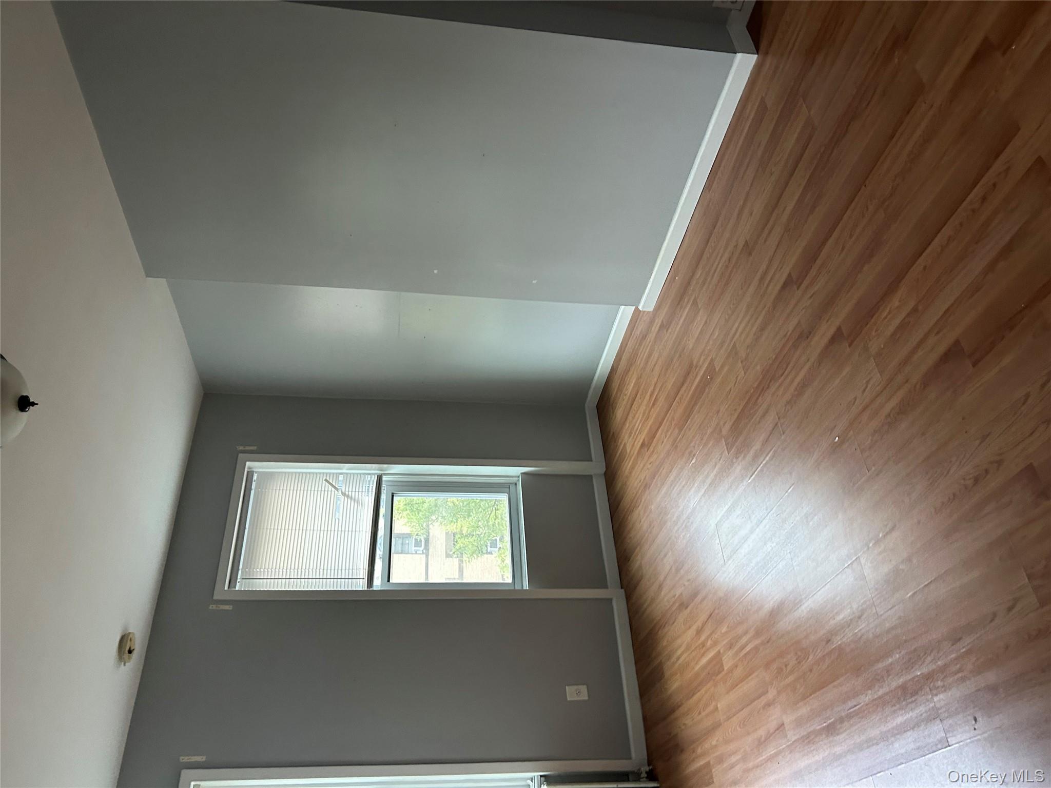 1737 Grove Street Queens, NY 11385 - Photo 1 of 6 an empty room with wooden floor and windows