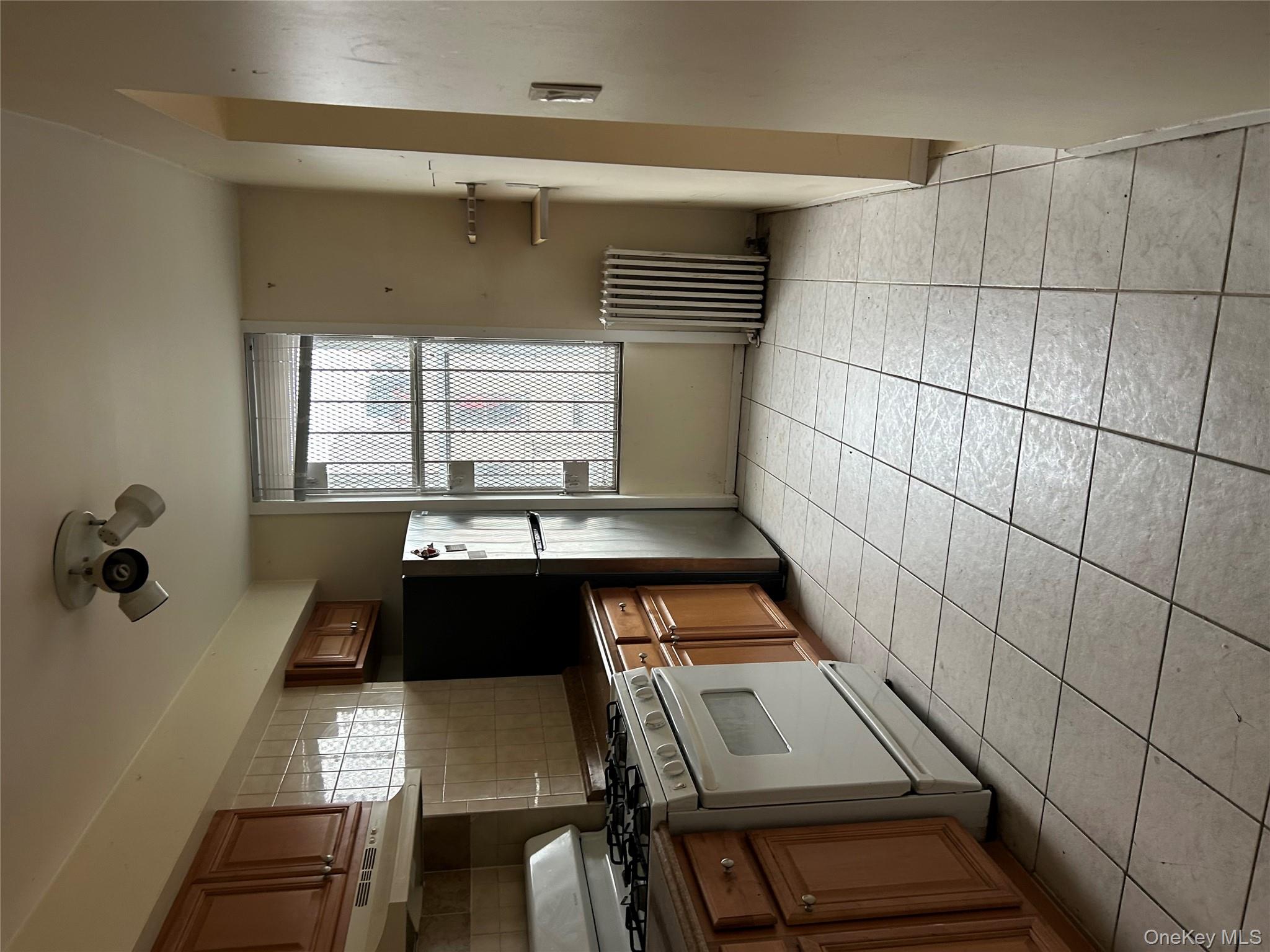1737 Grove Street Queens, NY 11385 - Photo 4 of 6 a kitchen with stainless steel appliances a stove a sink and a refrigerator