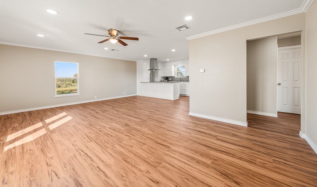 8896 Gholson Road Waco, TX 76705 - Photo 2 of 58 a view of a kitchen with wooden floor and a ceiling fan