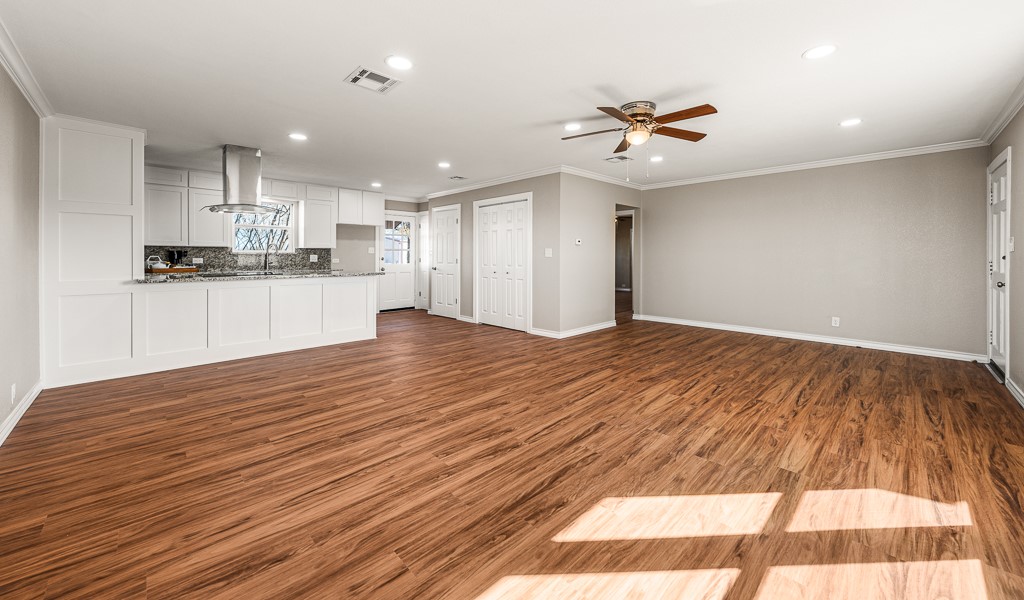 8896 Gholson Road Waco, TX 76705 - Photo 5 of 58 a view of a kitchen with kitchen island a refrigerator wooden floor and a sink