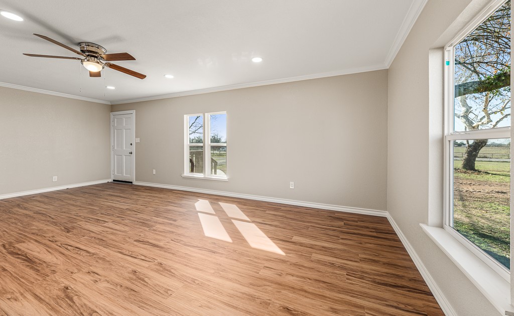 8896 Gholson Road Waco, TX 76705 - Photo 6 of 58 a view of empty room with wooden floor and fan
