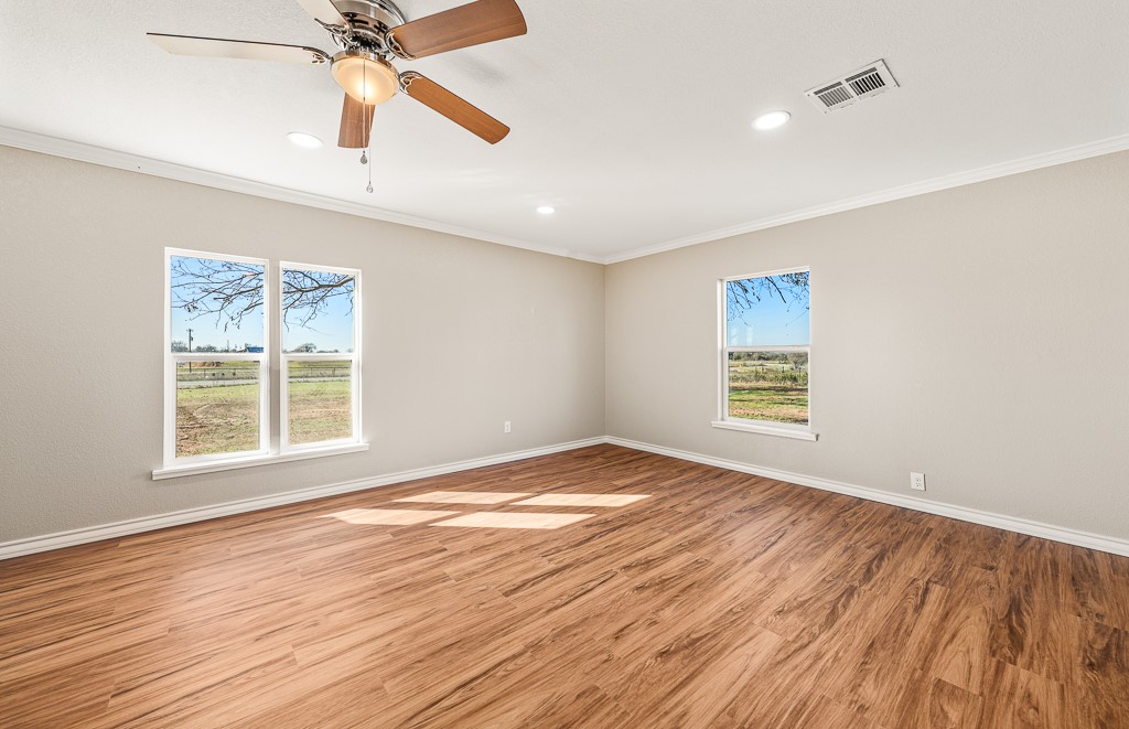 8896 Gholson Road Waco, TX 76705 - Photo 7 of 58 a view of an empty room with wooden floor and a window