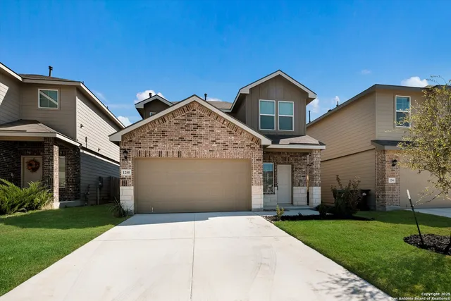 a view of a house with a yard and large tree