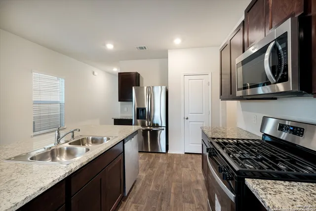 a kitchen with stainless steel appliances granite countertop a sink stove and refrigerator