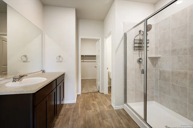 a bathroom with a double vanity sink a mirror and shower