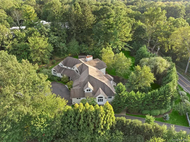 a view of a house with a yard and large trees