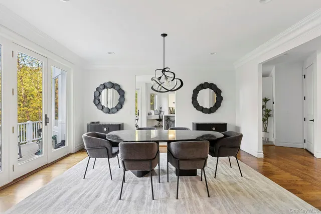 a dining room with wooden floor a glass table and chairs