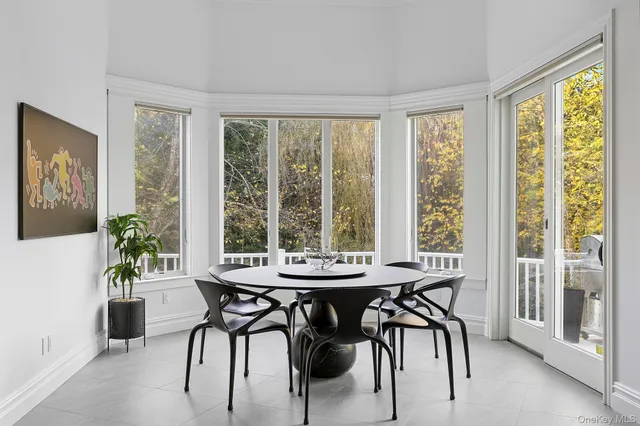 a dining room with furniture and large windows