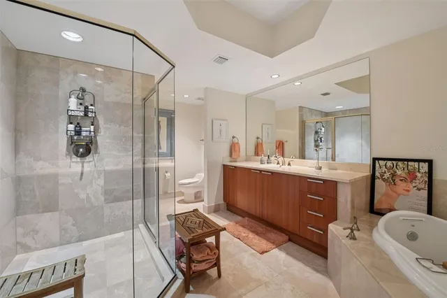 a bathroom with a tub sink mirror and shower