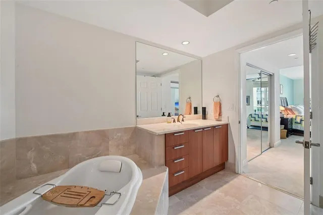 a bathroom with a tub sink and mirror