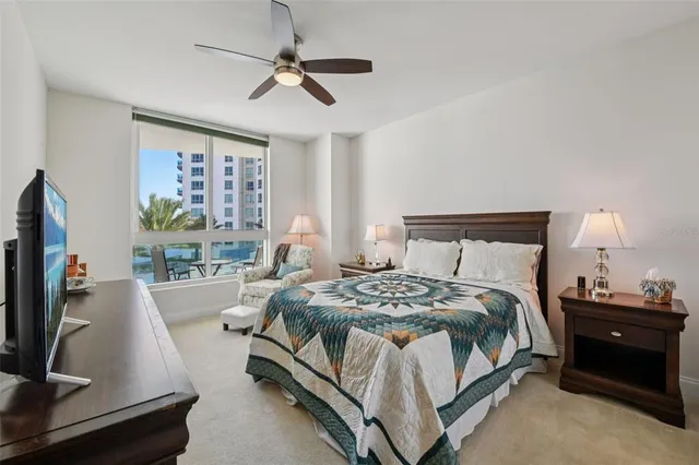 a bedroom with a bed and a flat tv screen on dresser