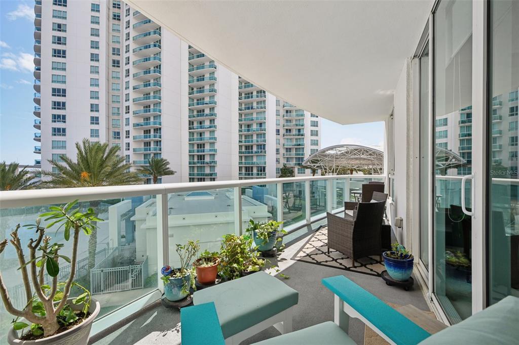 241 Riverside Drive, Unit 305 Daytona Beach, FL 32117 - Photo 18 of 35 a view of a balcony with chair and potted plants