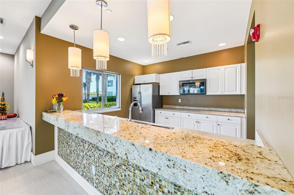 241 Riverside Drive, Unit 305 Daytona Beach, FL 32117 - Photo 31 of 35 a large kitchen with kitchen island a sink stainless steel appliances and cabinets