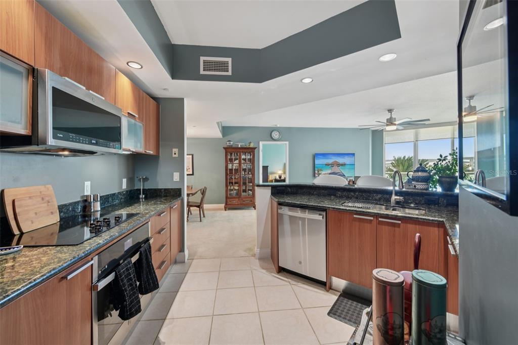 241 Riverside Drive, Unit 305 Daytona Beach, FL 32117 - Photo 6 of 35 a kitchen with stainless steel appliances granite countertop a sink and a stove