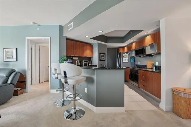 a living room with furniture a flat screen tv and kitchen view