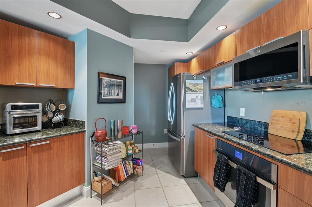 241 Riverside Drive, Unit 305 Daytona Beach, FL 32117 - Photo 8 of 35 a kitchen with stainless steel appliances granite countertop a sink stove and microwave
