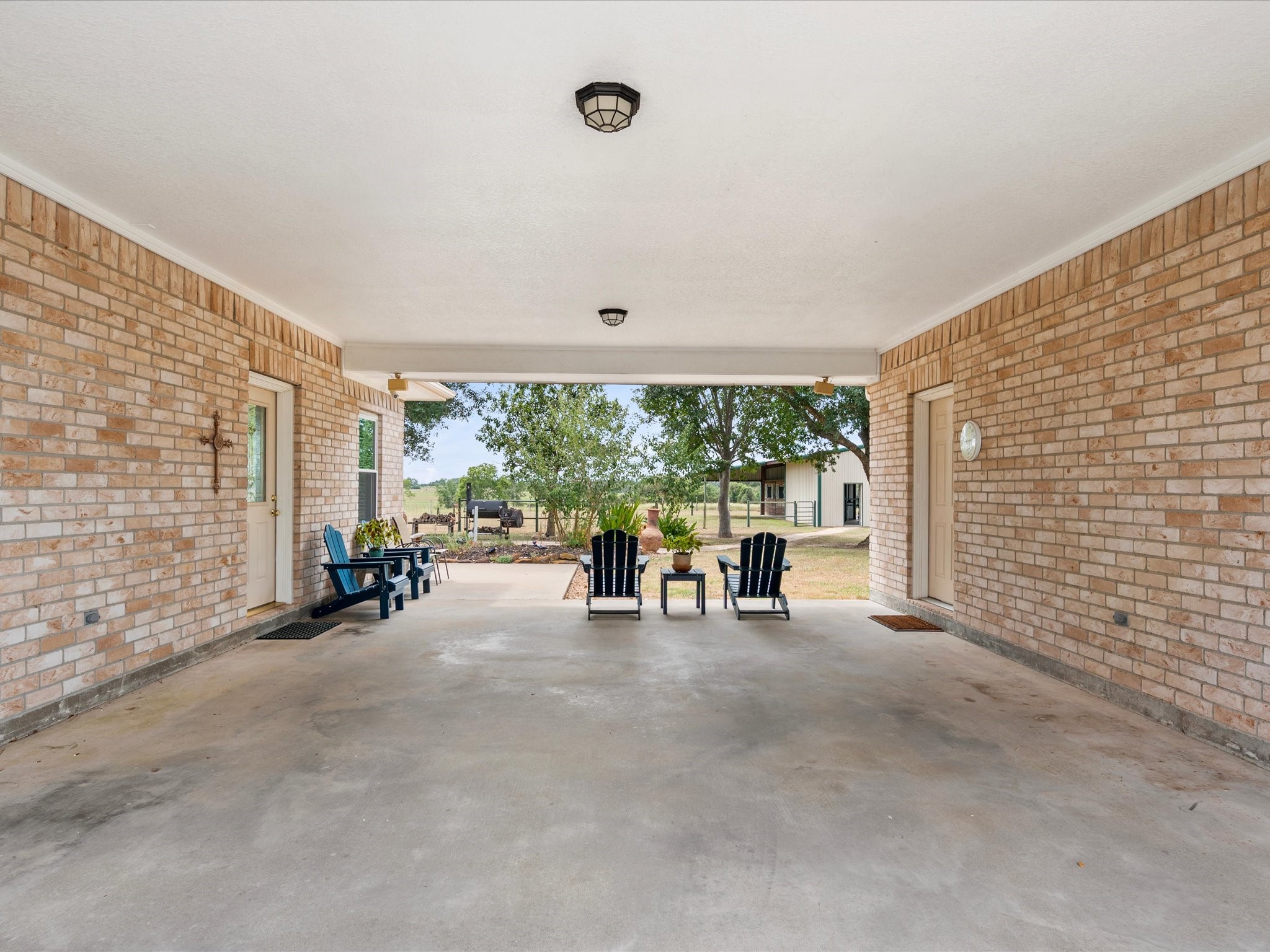 19929 Pierceall Road Hempstead, TX 77445 - Photo 10 of 50 Connecting the front and back of the property, the porte-cochere provides convenient access to both the home and garage while adding to the home's thoughtful design.