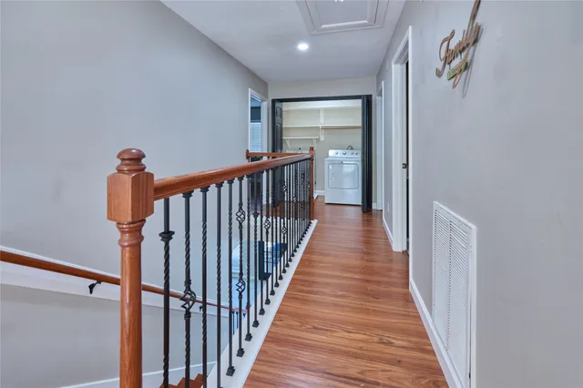 a view of a hallway with wooden floor and staircase