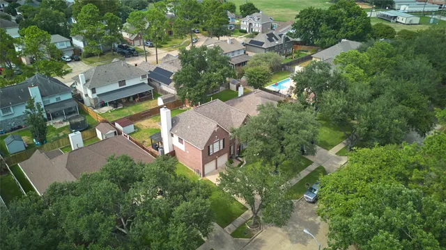 an aerial view of residential house with outdoor space and trees all around