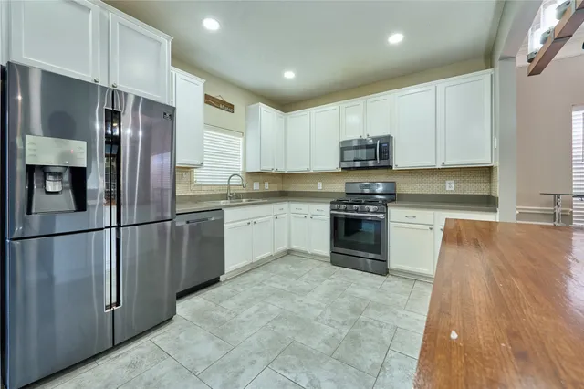 a kitchen with stainless steel appliances granite countertop a refrigerator sink and cabinets