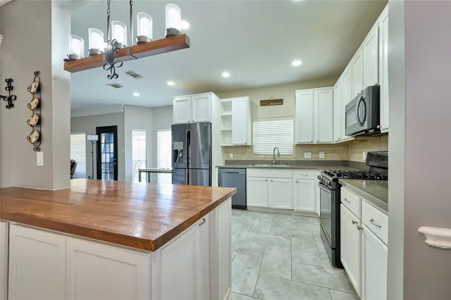 a kitchen with stainless steel appliances granite countertop a sink refrigerator and cabinets