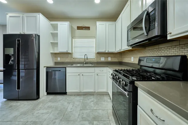 a kitchen with stainless steel appliances granite countertop a stove a refrigerator and a microwave