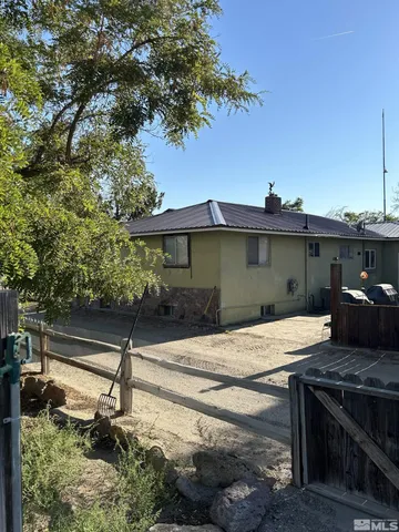 a view of a house with backyard and a tree