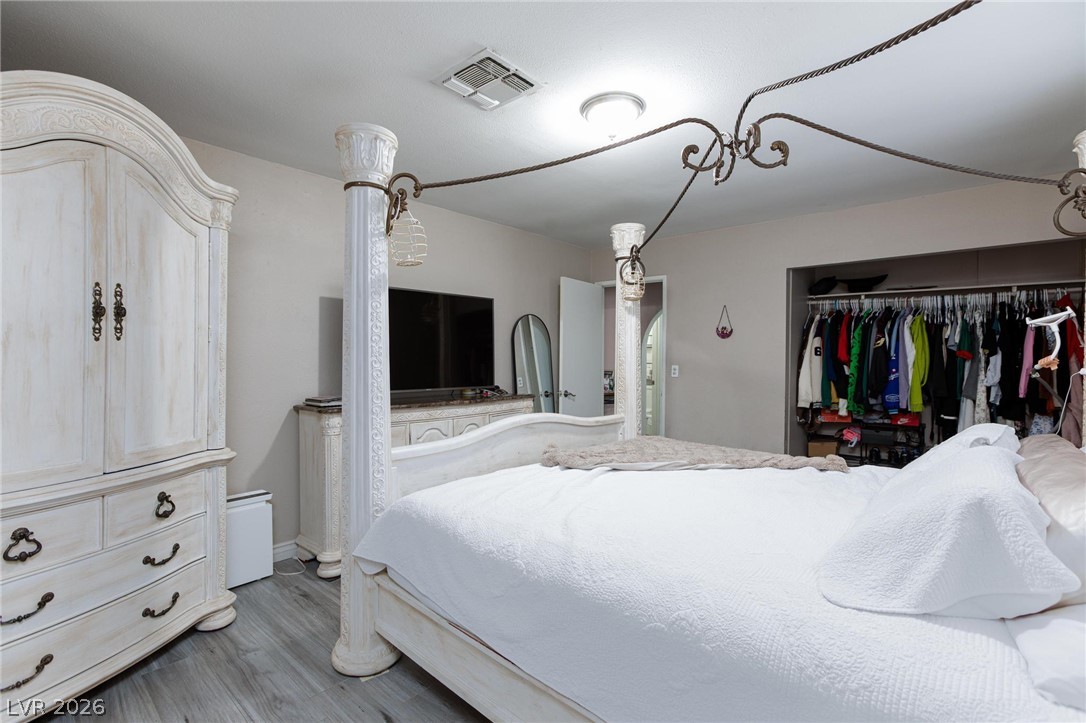 3640 North Walnut Road Las Vegas, NV 89115 - Photo 15 of 38 Ornate four-poster bed and hardwood style flooring create a restful bedroom retreat.