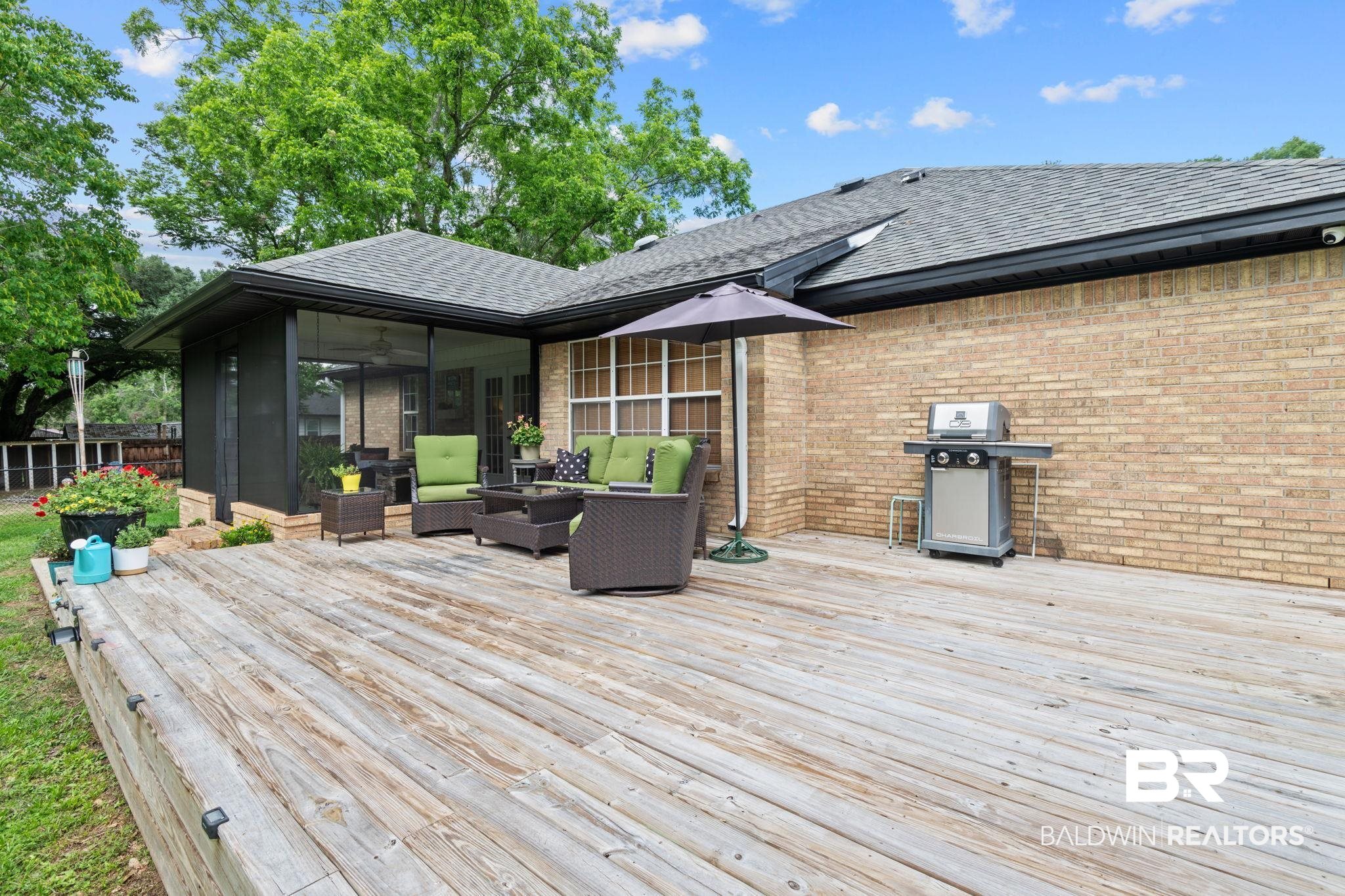 5936 Lundy Road Theodore, AL 36582 - Photo 27 of 32 Expansive outdoor deck featuring wood planking, a screened patio, and a brick exterior facade