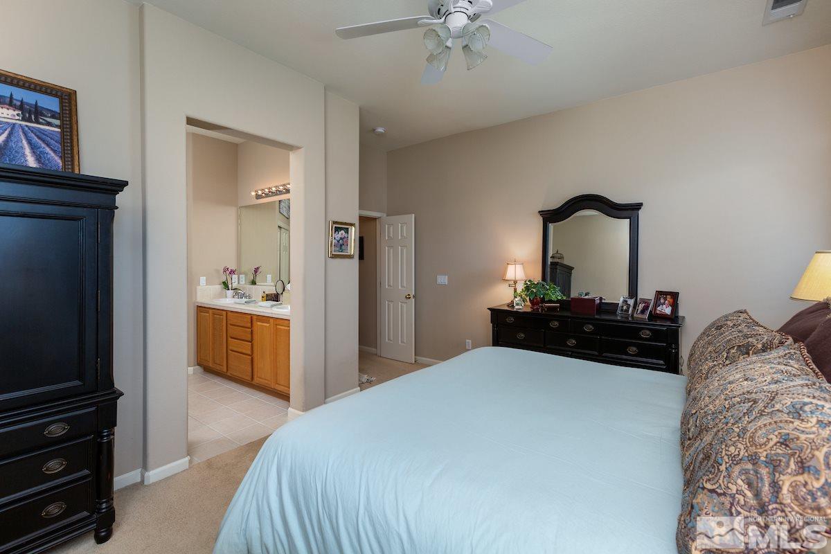 10600 Sterling Ridge Way Reno, NV 89521 - Photo 12 of 25 a bedroom with a bed and a chandelier