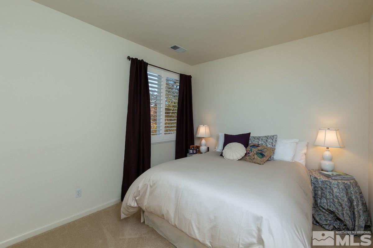 10600 Sterling Ridge Way Reno, NV 89521 - Photo 19 of 25 a bedroom with a bed and a lamp next to a window