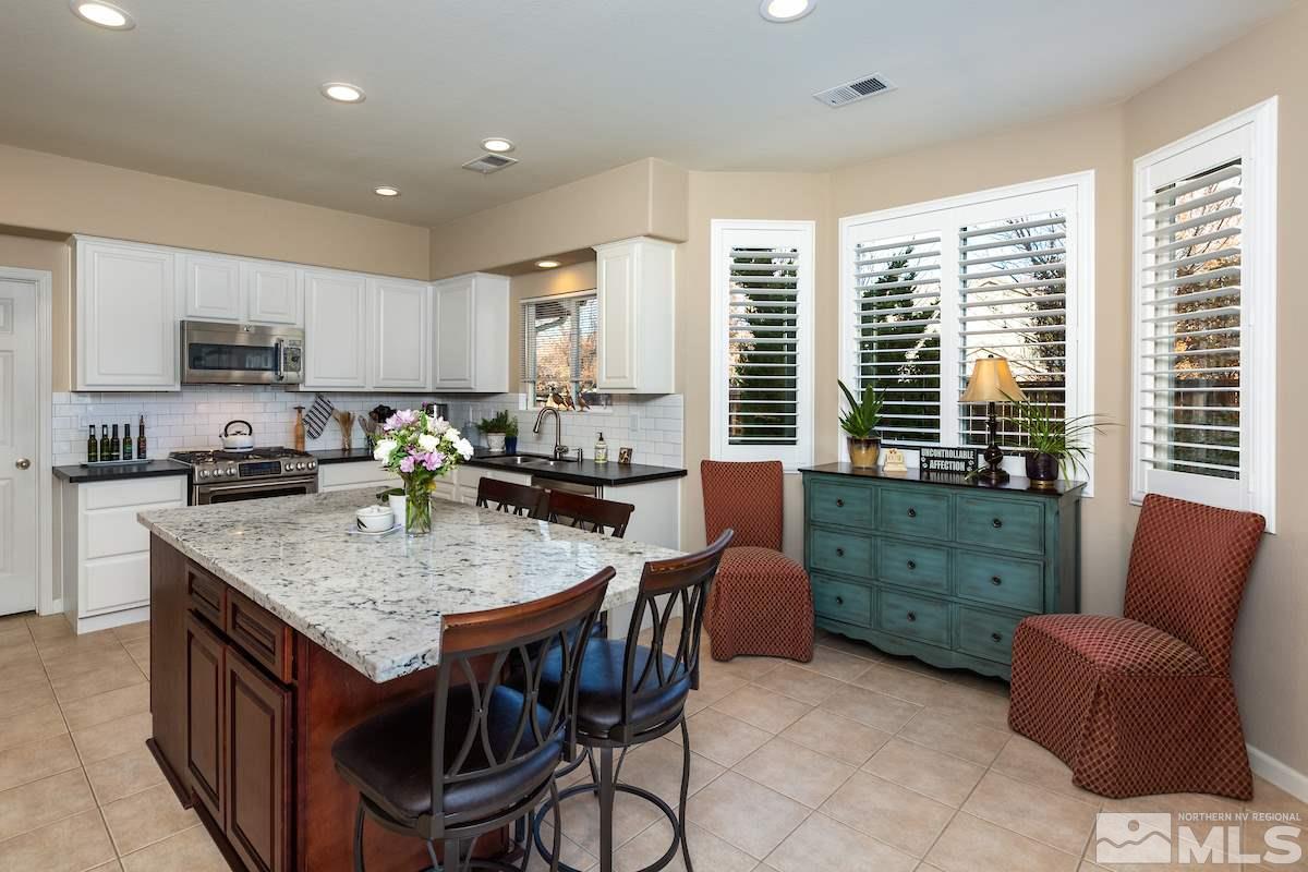 10600 Sterling Ridge Way Reno, NV 89521 - Photo 6 of 25 a kitchen with stainless steel appliances granite countertop a table chairs sink refrigerator and microwave