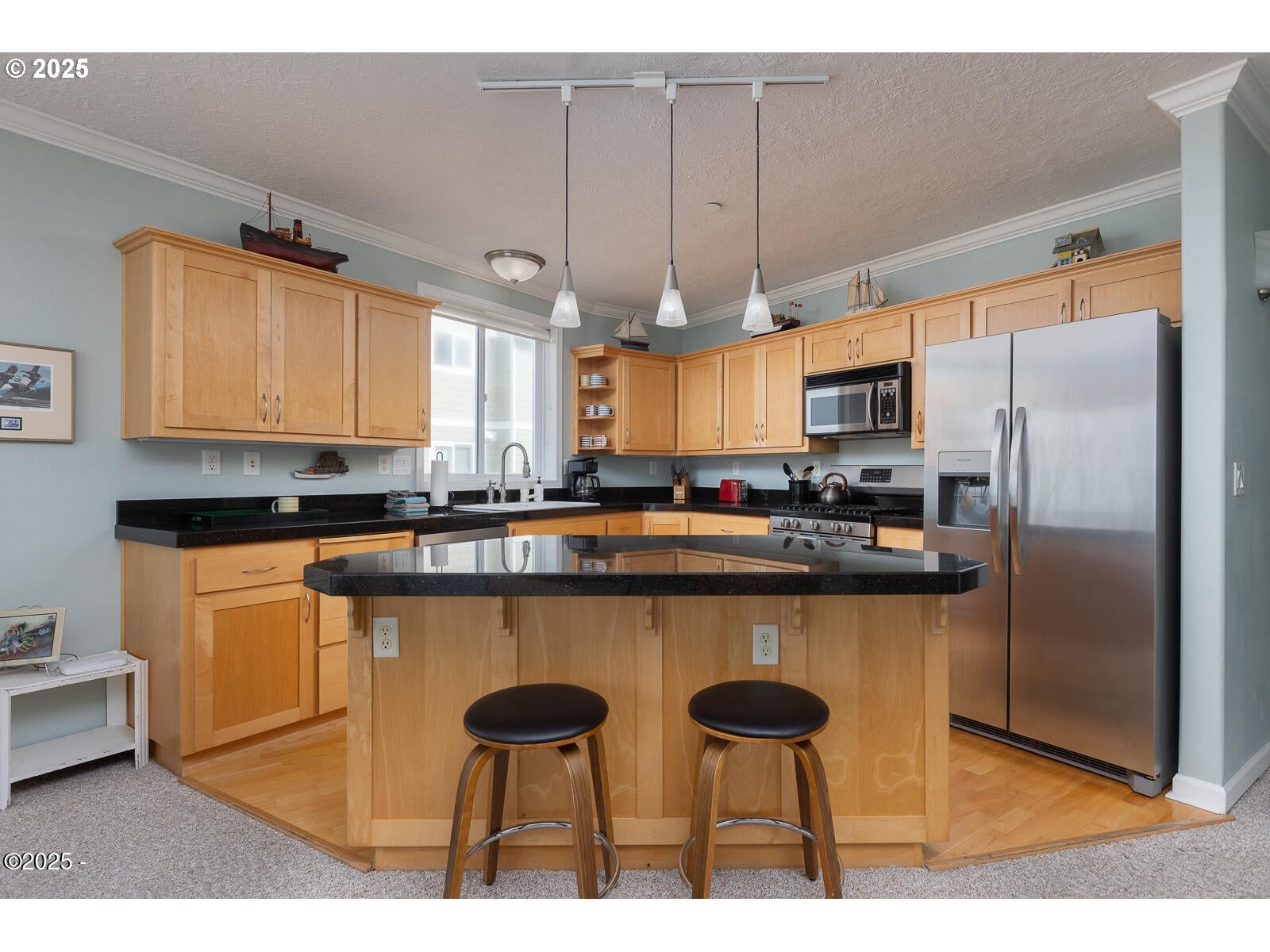 1113 Highway 101, Unit 48 Depoe Bay, OR 97341 - Photo 14 of 40 a kitchen with stainless steel appliances a table chairs refrigerator and microwave