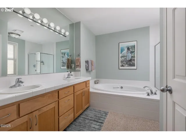 a bathroom with a tub a sink and mirror