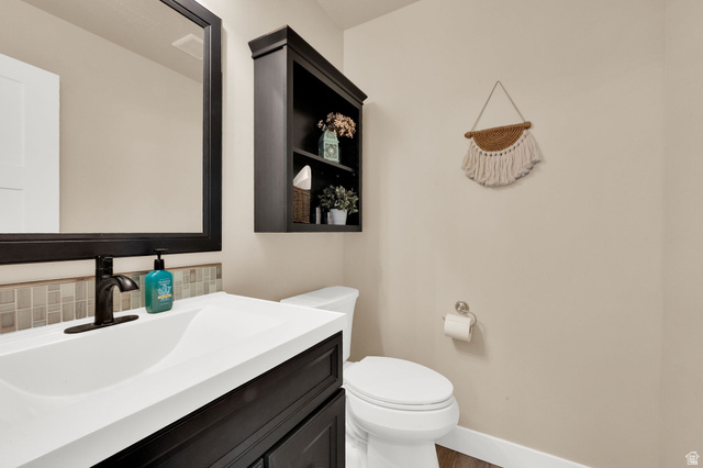 1857 Thunder Gulch Road Eagle Mountain, UT 84005 - Photo 17 of 50 Bathroom featuring a dark wood-finish vanity with an integrated white sink, a matte black faucet, and a rectangular mirror