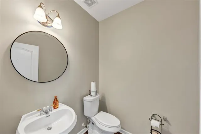 a bathroom with a toilet a sink and mirror
