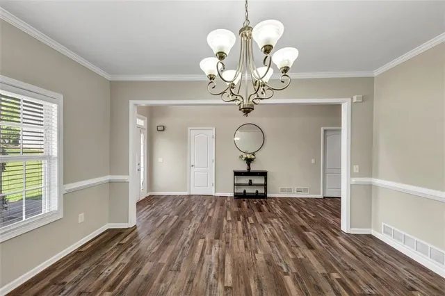 a view of a room with wooden floor and chandelier