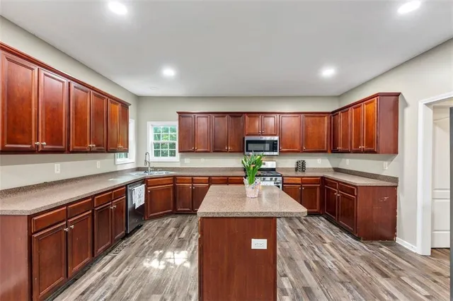 a kitchen with stainless steel appliances granite countertop sink stove top oven and cabinets
