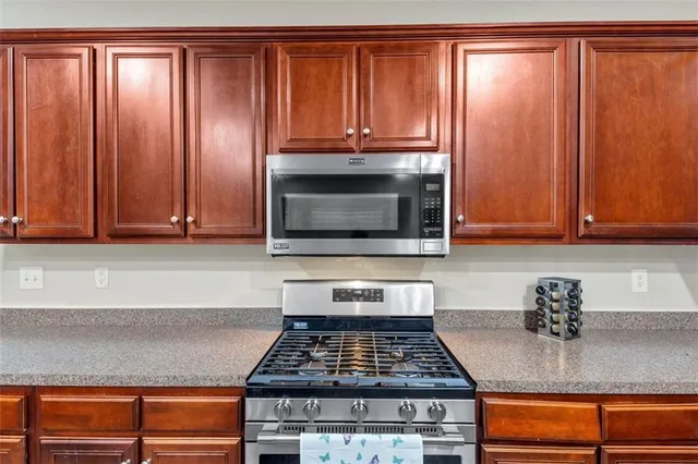a kitchen with granite countertop cabinets and a stove top oven