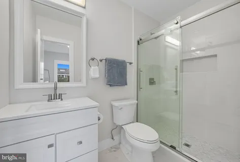 a bathroom with a sink toilet a mirror and shower