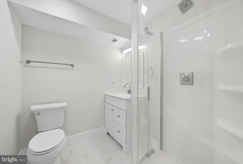 a bathroom with a toilet a sink a mirror and vanity