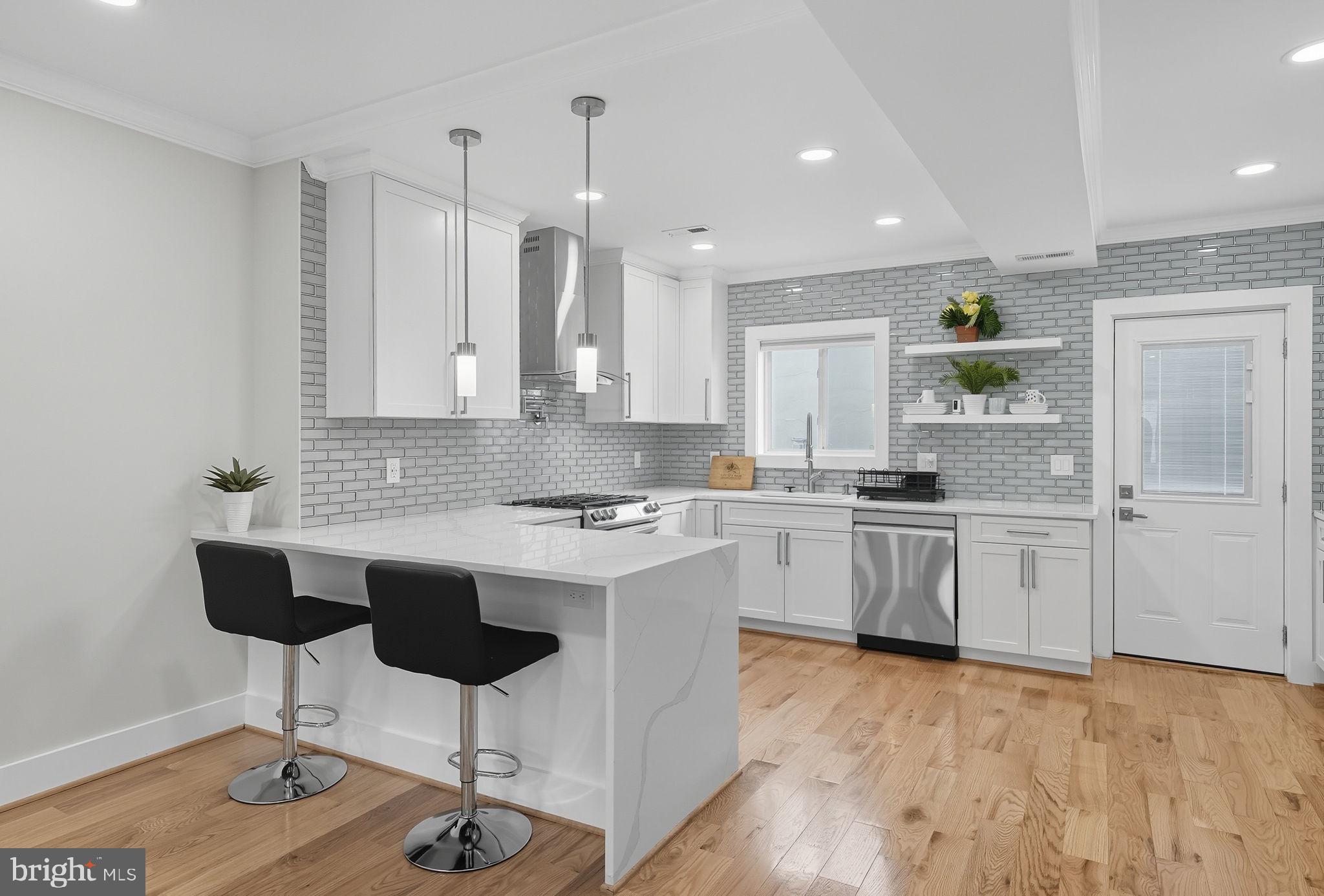 4902 4th Street Northwest Washington, DC 20011 - Photo 7 of 22 a kitchen with granite countertop white cabinets and white appliances