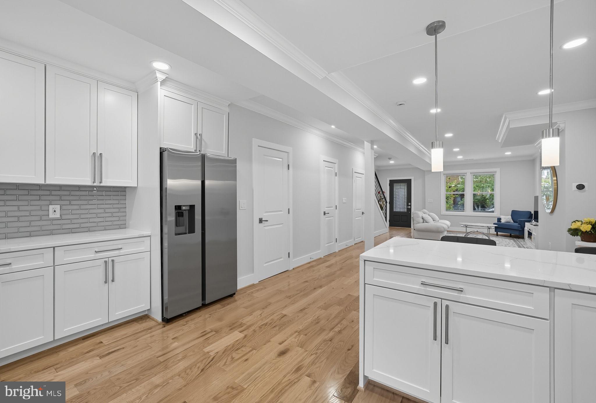 4902 4th Street Northwest Washington, DC 20011 - Photo 8 of 22 a kitchen with kitchen island white cabinets appliances and wooden floor